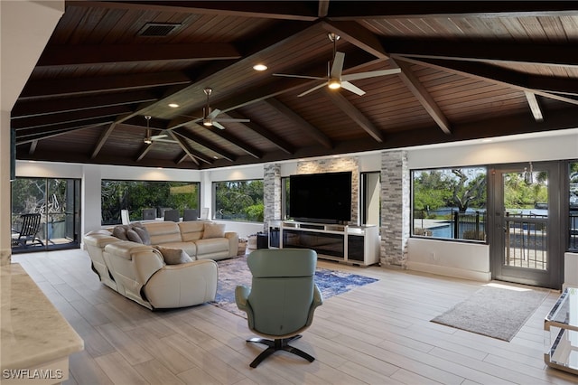 living room with plenty of natural light, beam ceiling, visible vents, and wood finished floors