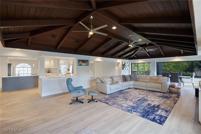 living room featuring vaulted ceiling with beams, plenty of natural light, visible vents, and ceiling fan