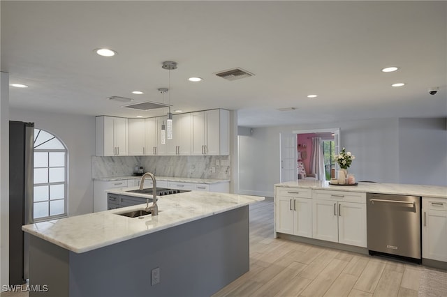 kitchen with light wood finished floors, tasteful backsplash, visible vents, white cabinetry, and dishwasher