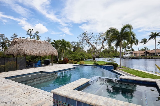 view of pool with a patio, a water view, and a pool with connected hot tub