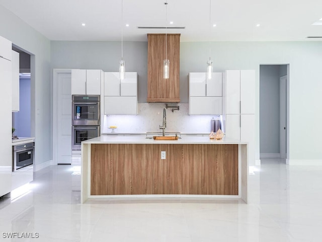 kitchen featuring modern cabinets, white cabinetry, light countertops, and a sink