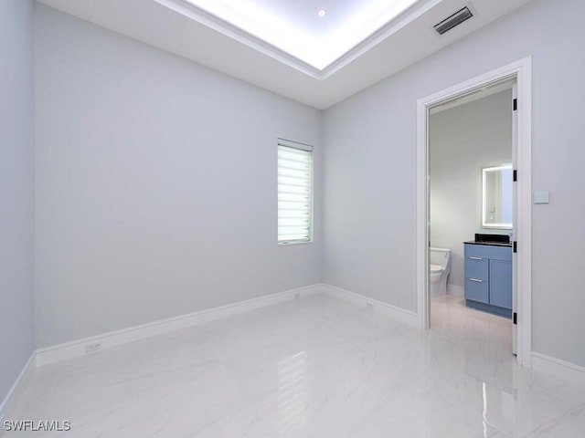 unfurnished bedroom featuring marble finish floor, baseboards, visible vents, and connected bathroom