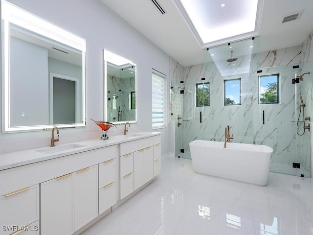 bathroom with a freestanding tub, a sink, visible vents, a marble finish shower, and double vanity