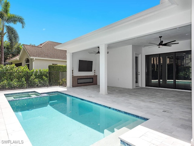 view of swimming pool with a ceiling fan, a pool with connected hot tub, a patio area, and fence