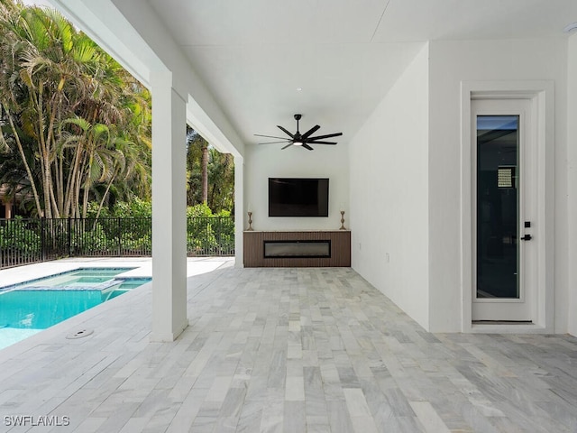 view of swimming pool with a patio, a pool with connected hot tub, fence, and a ceiling fan