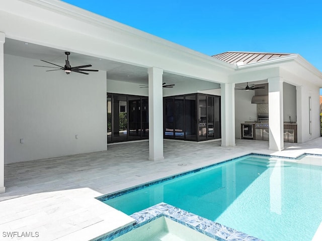 view of swimming pool featuring exterior kitchen, a patio area, and ceiling fan