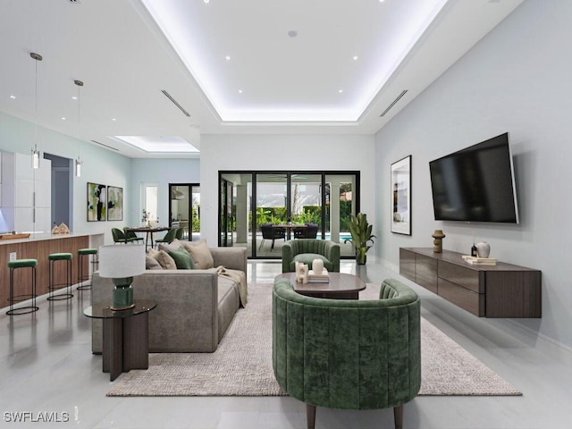 living area featuring a tray ceiling, recessed lighting, and baseboards