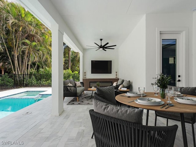 view of patio featuring ceiling fan, an outdoor hangout area, fence, a pool with connected hot tub, and outdoor dining space