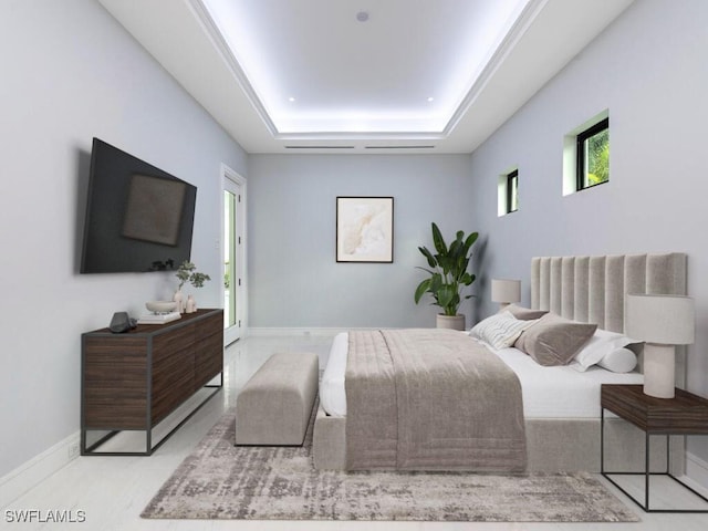 bedroom with a raised ceiling and baseboards