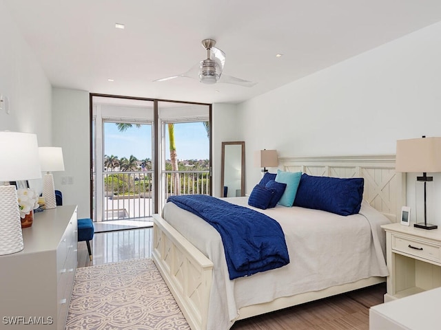 bedroom with a wall of windows, wood finished floors, access to exterior, and a ceiling fan