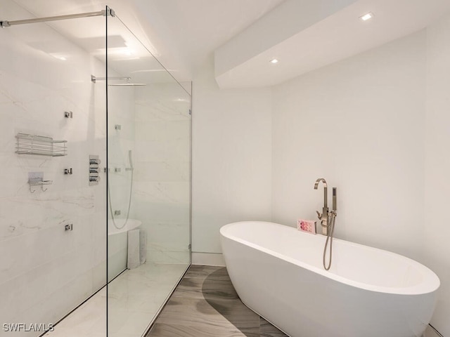 full bath featuring a soaking tub, recessed lighting, and a marble finish shower