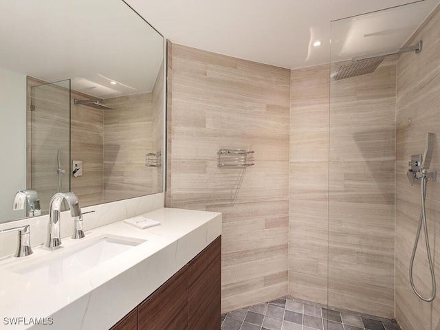 bathroom featuring tiled shower and vanity