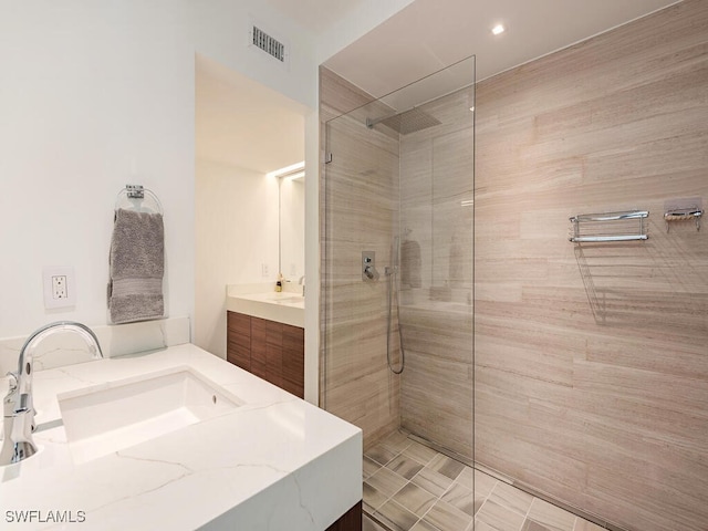 bathroom featuring visible vents, vanity, and walk in shower