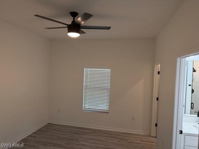 spare room with ceiling fan and dark hardwood / wood-style flooring