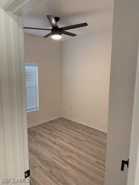 empty room with hardwood / wood-style flooring and ceiling fan