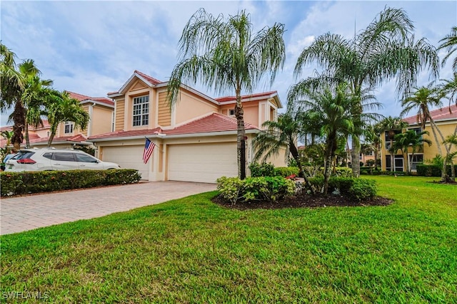 view of front of home with a garage, stucco siding, decorative driveway, and a front yard