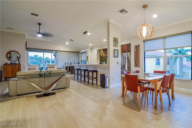 dining area with light wood-style floors, visible vents, and crown molding