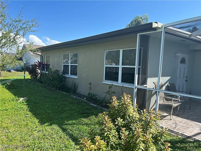 view of home's exterior with a patio area and a lawn