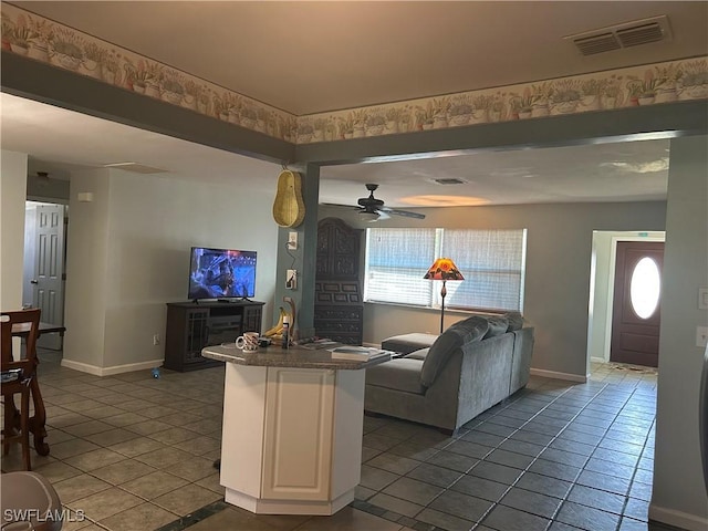 living room with dark tile patterned flooring and ceiling fan