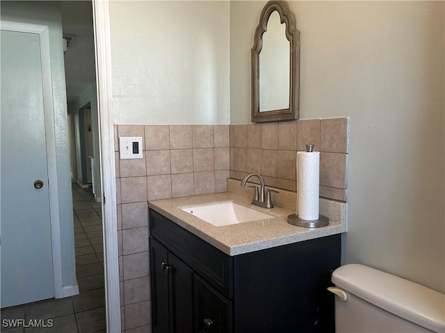 bathroom with vanity, tile walls, and toilet