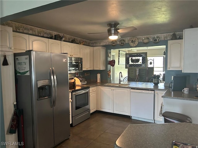 kitchen featuring stainless steel appliances, sink, white cabinets, and dark tile patterned floors