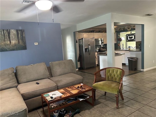 living room with ceiling fan and tile patterned flooring