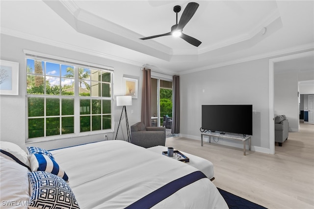 bedroom featuring crown molding, ceiling fan, a tray ceiling, and light hardwood / wood-style flooring