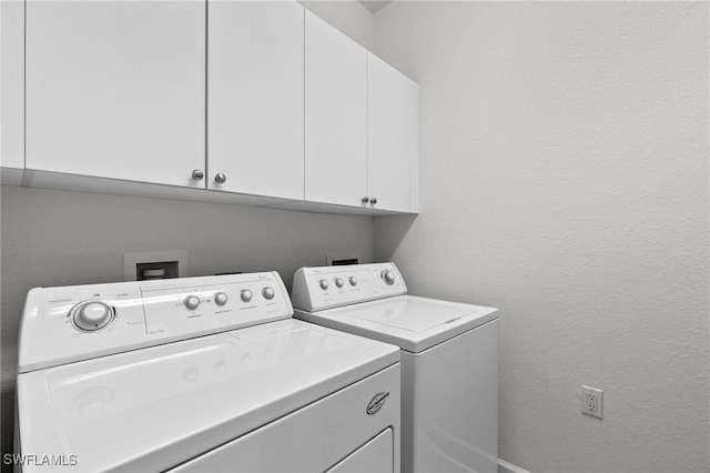 clothes washing area featuring cabinets and washing machine and dryer