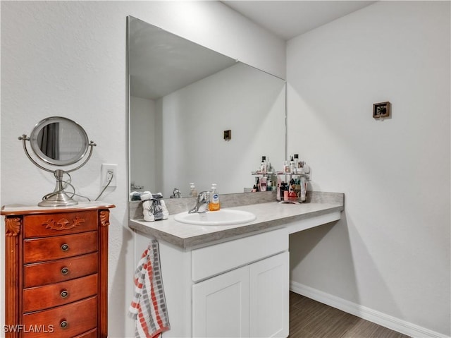 bathroom featuring vanity, baseboards, and wood finished floors