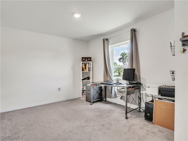 office area featuring light carpet and baseboards