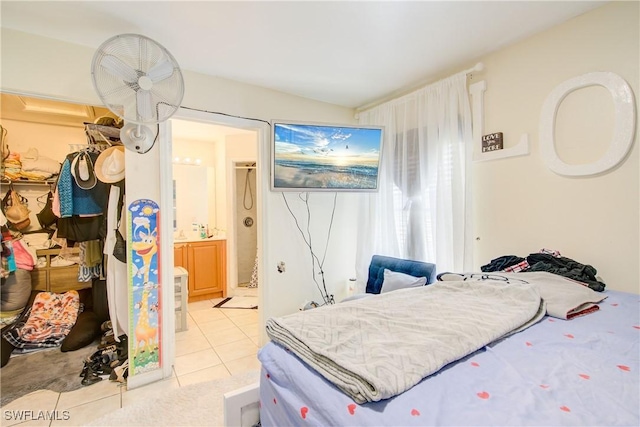 tiled bedroom with ensuite bath, a spacious closet, and a closet