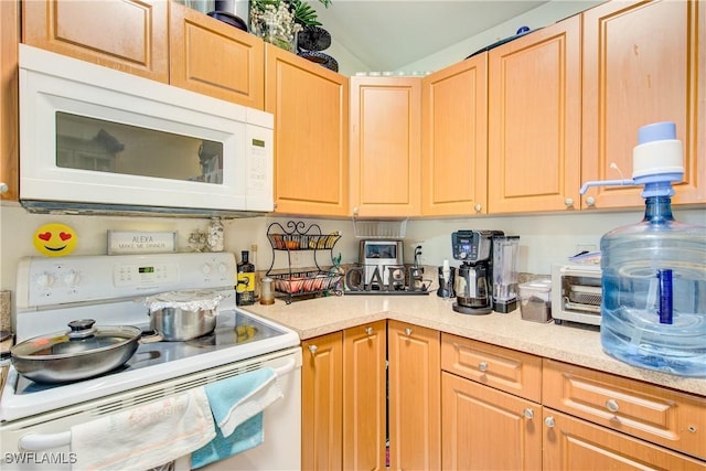 kitchen featuring white appliances and light brown cabinets