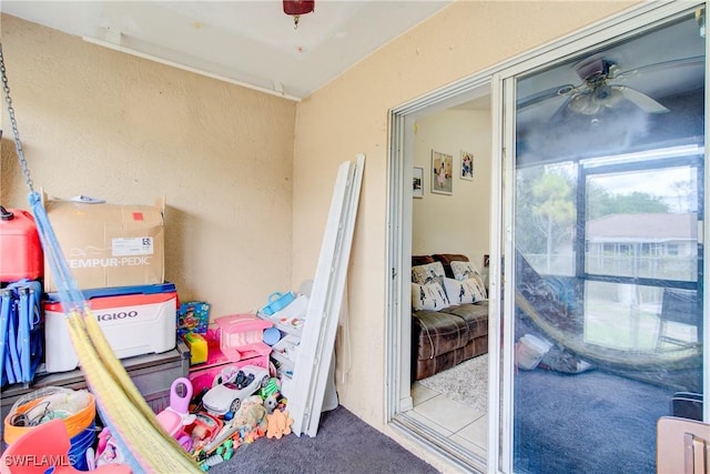 interior space featuring ceiling fan and carpet flooring