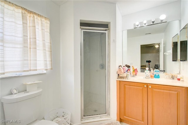 bathroom with vanity, a shower with door, and toilet