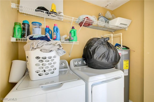 clothes washing area featuring water heater and washer and dryer