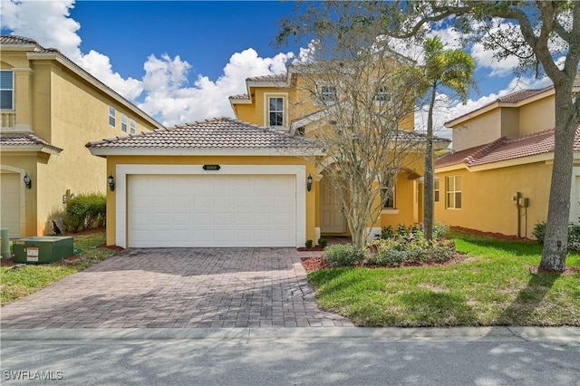 mediterranean / spanish-style house featuring a garage and a front yard