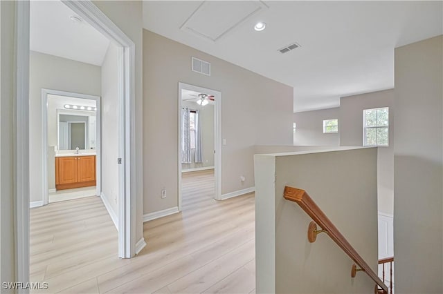 corridor with sink and light hardwood / wood-style floors