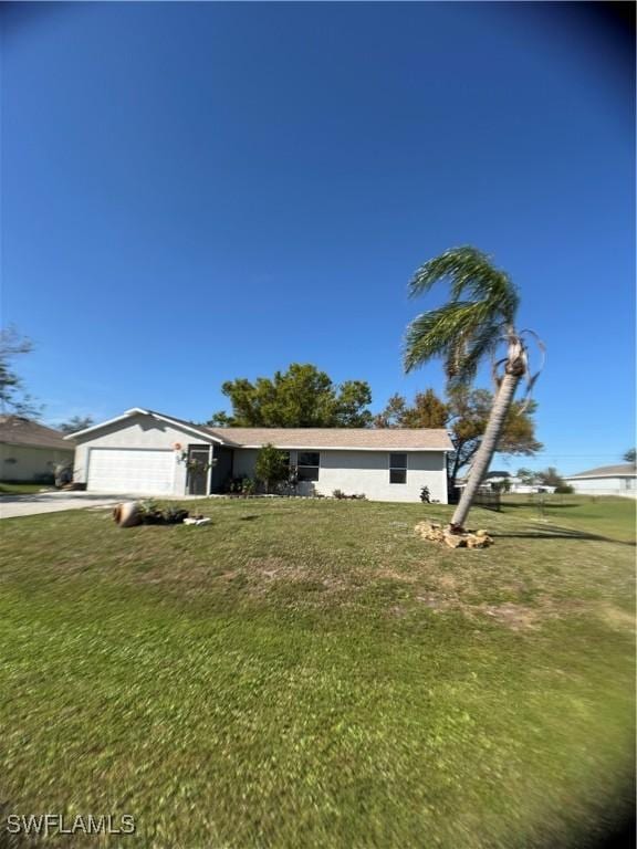 view of front of home with concrete driveway, an attached garage, and a front lawn