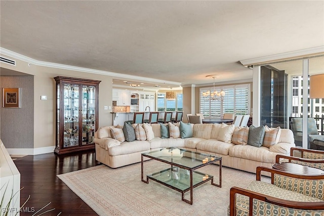 living room with crown molding, hardwood / wood-style floors, and a notable chandelier