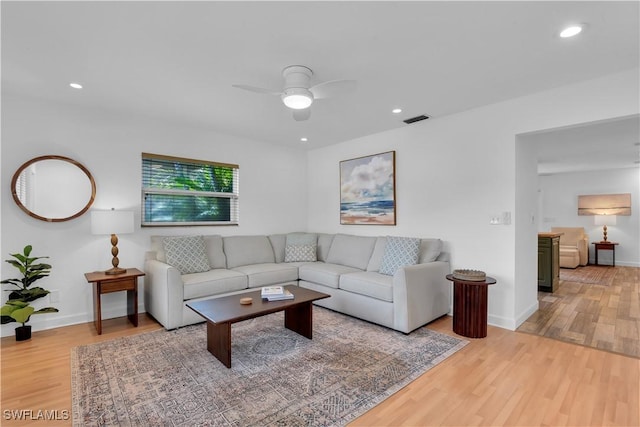 living room with wood-type flooring and ceiling fan