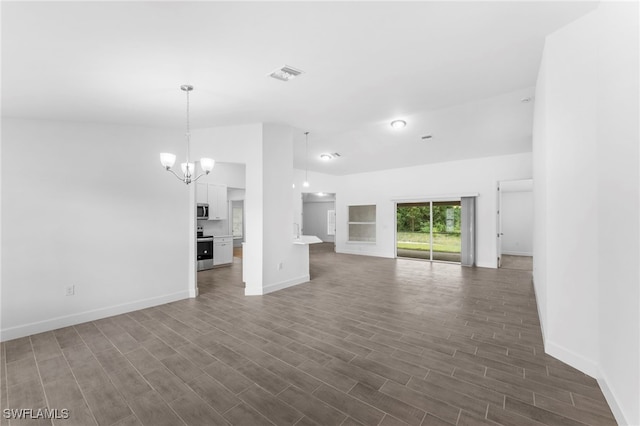 unfurnished living room featuring lofted ceiling, dark hardwood / wood-style floors, and a chandelier