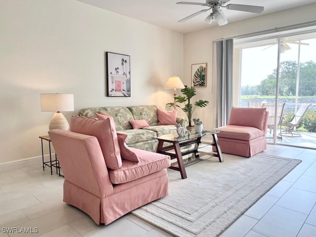 living room featuring a ceiling fan, baseboards, and light tile patterned floors