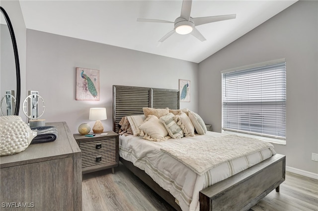 bedroom featuring light hardwood / wood-style flooring, ceiling fan, and vaulted ceiling