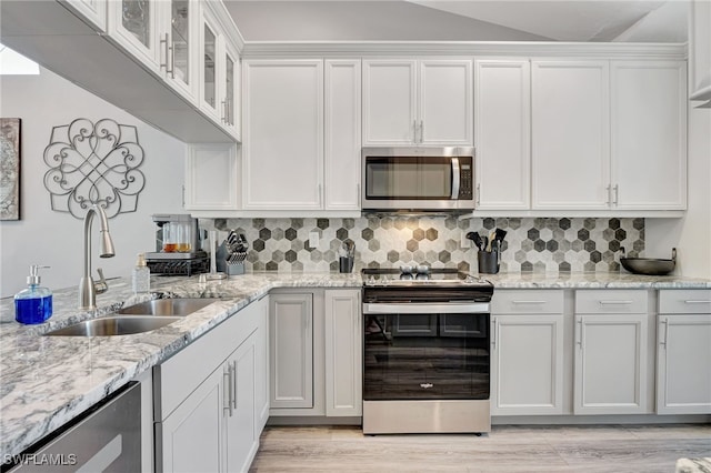 kitchen featuring stainless steel appliances, sink, decorative backsplash, and white cabinets