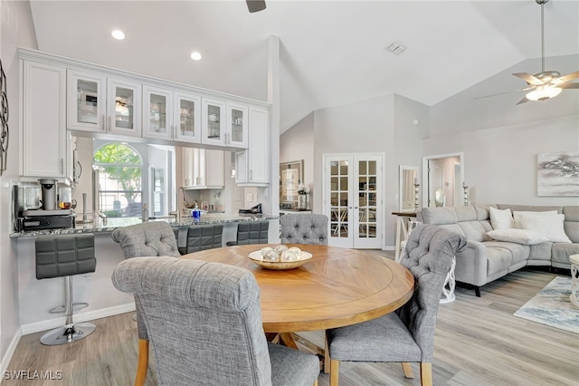 dining area with french doors, ceiling fan, light hardwood / wood-style floors, and vaulted ceiling