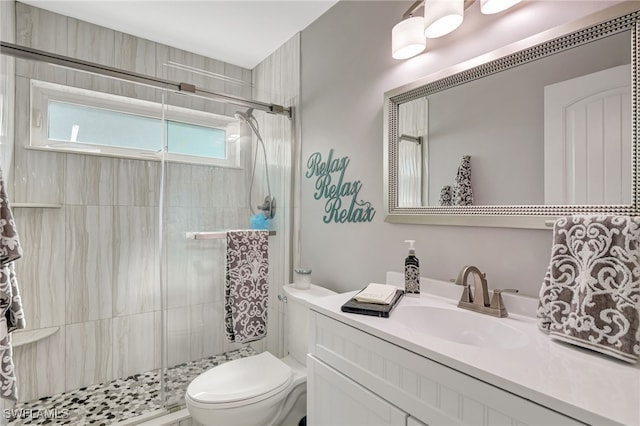 bathroom featuring walk in shower, vanity, and toilet