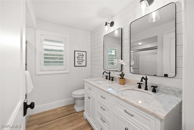4611 Crayton Rd, Naples, FL 34103 - full bathroom with plenty of natural light, double vanity, toilet, and wood finished floors