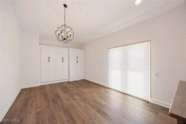 4611 Crayton Rd, Naples, FL 34103 - unfurnished dining area with baseboards, a chandelier, and hardwood / wood-style floors
