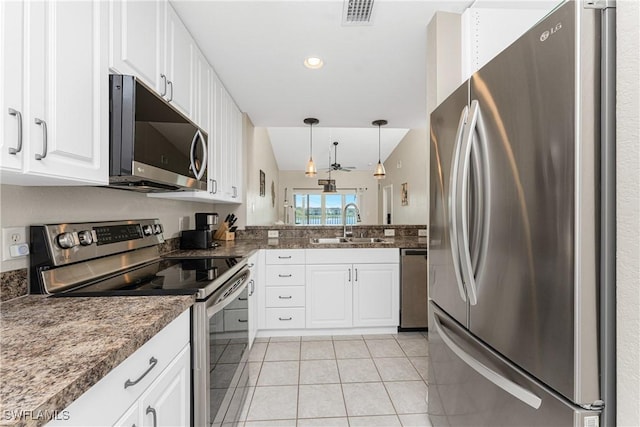 kitchen with appliances with stainless steel finishes, a sink, visible vents, and white cabinetry