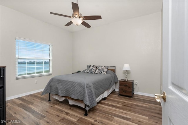 bedroom with ceiling fan, baseboards, and wood finished floors